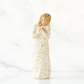 Decorative angel figurine with gold and white patterns on a white background