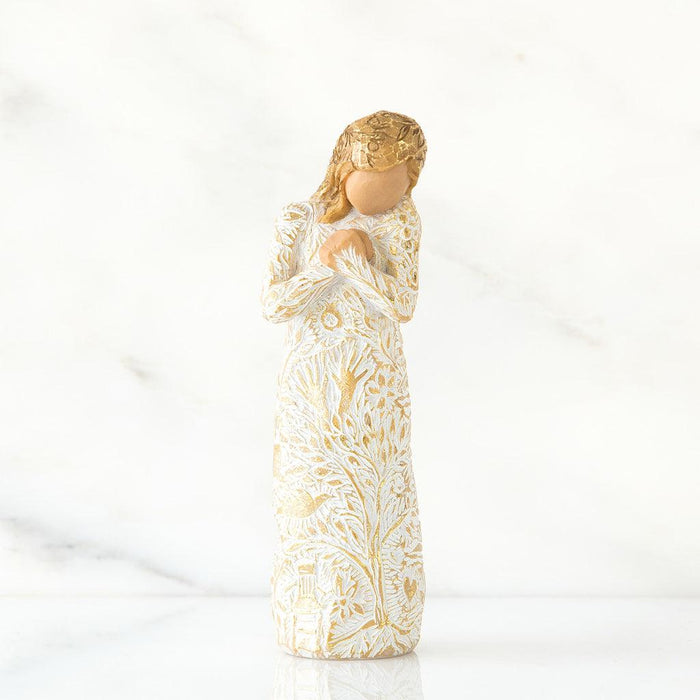 Decorative angel figurine with gold and white patterns on a white background