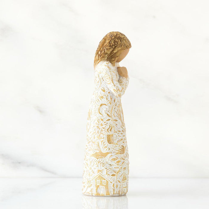 Statue of a woman in a white dress with gold detailing on a white background