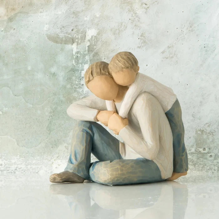 Father and son  embracing figurine against a textured light gray background