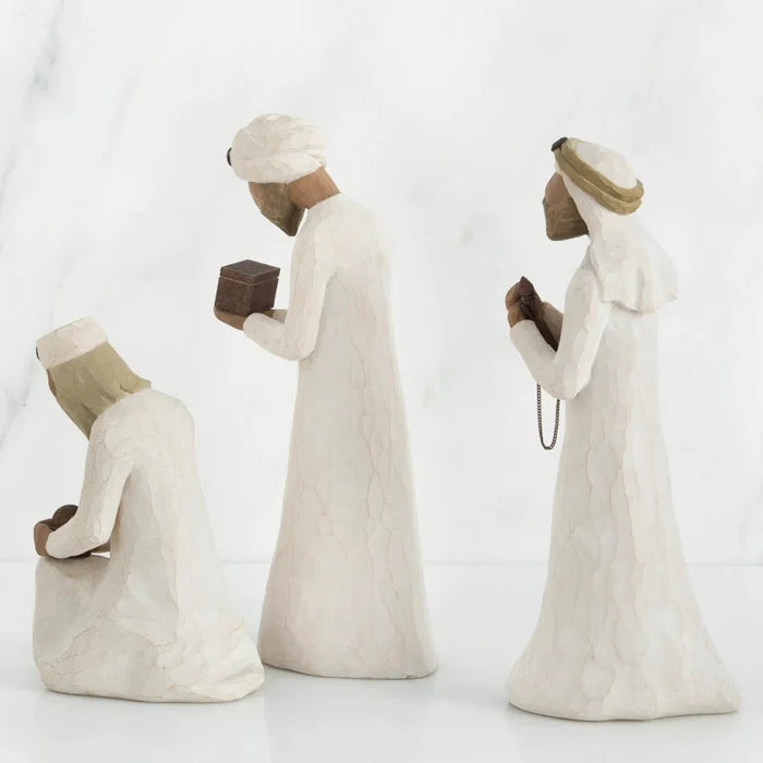 Three stone statues of people in traditional attire on a white background