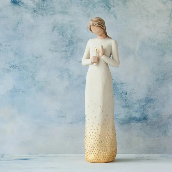 Statue of a woman holding a candle against a blue and gray background