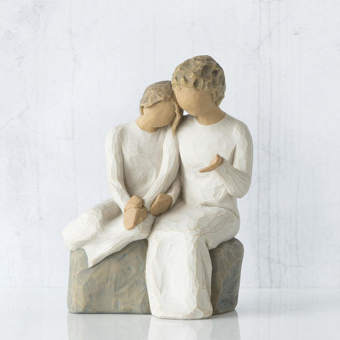 Statue of two people granddaughter and grandmother sitting together on a white background