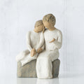 Statue of two people granddaughter and grandmother sitting together on a white background