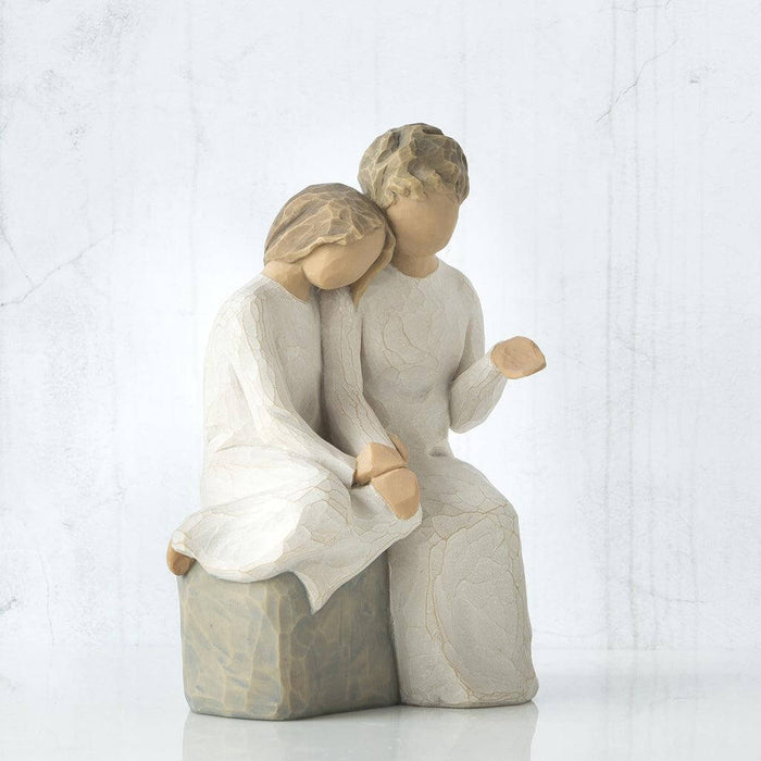 Statue of grandmother and granddaughter sitting together on a white background