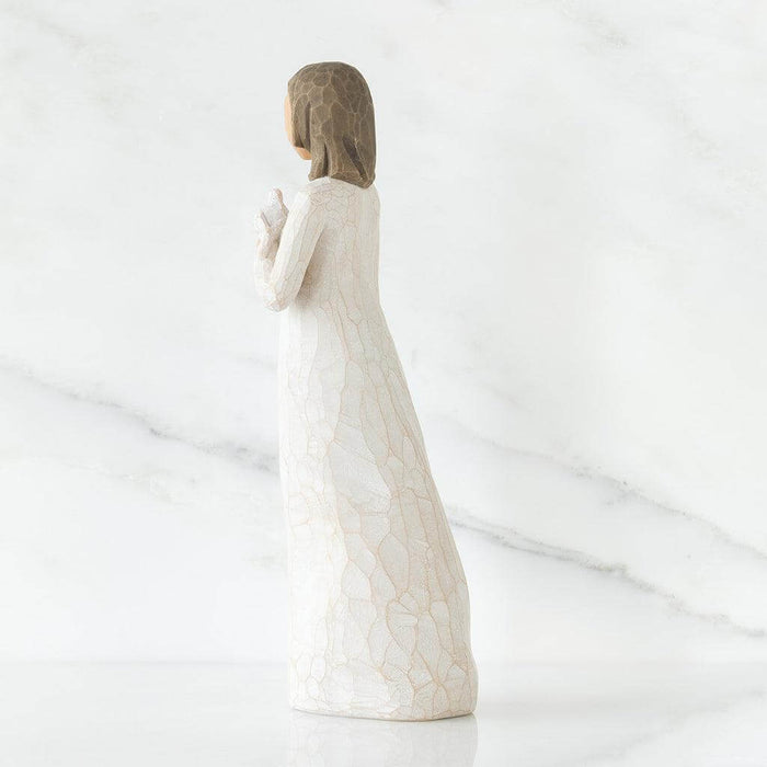 White ceramic figurine of a woman with brown hair on a white background