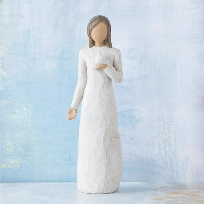 White figurine of a woman holding a Dove  against a light blue background