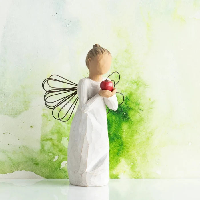 Decorative figurine of a woman holding an apple against a green and white abstract background
