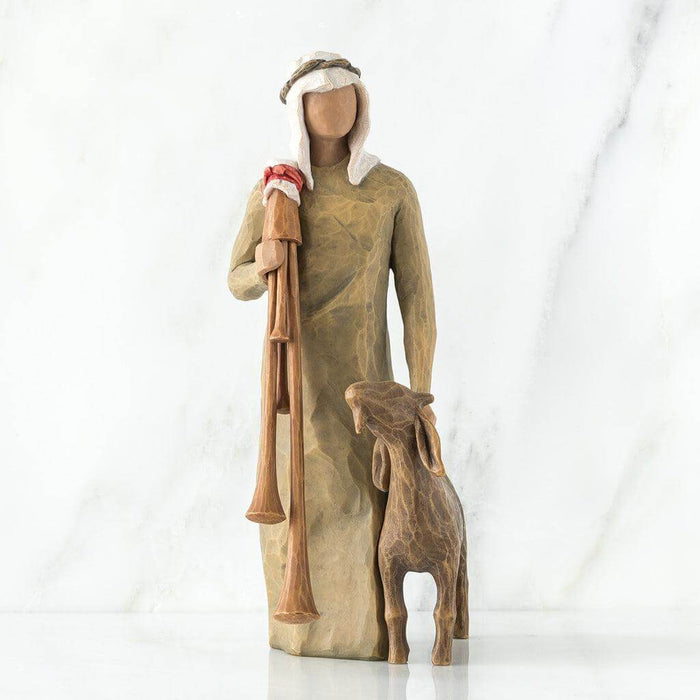 Wooden sculpture of a shepherd with a lamb on a white background