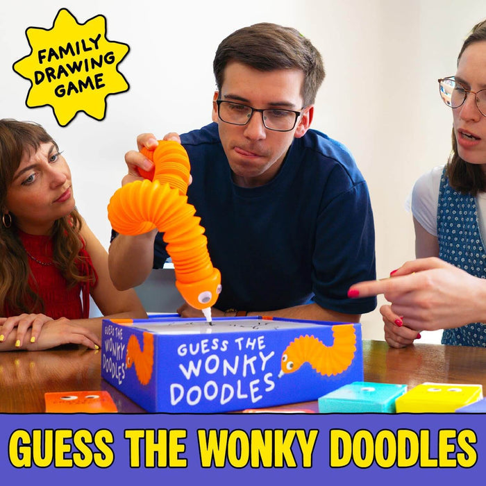 Three people play a drawing game using a flexible orange worm pen on a blue box labeled Guess the Wonky Doodles.